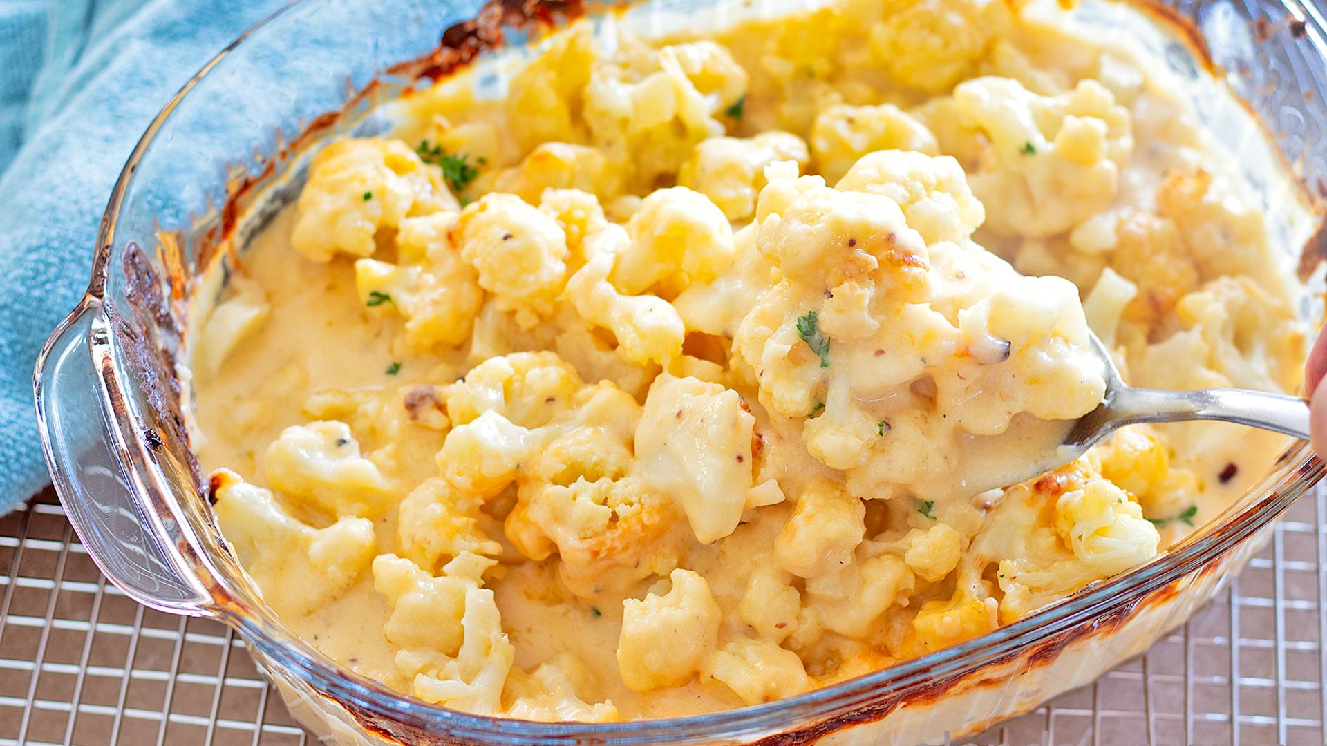 Cheesy Cauliflower in a clear glass baking dish.