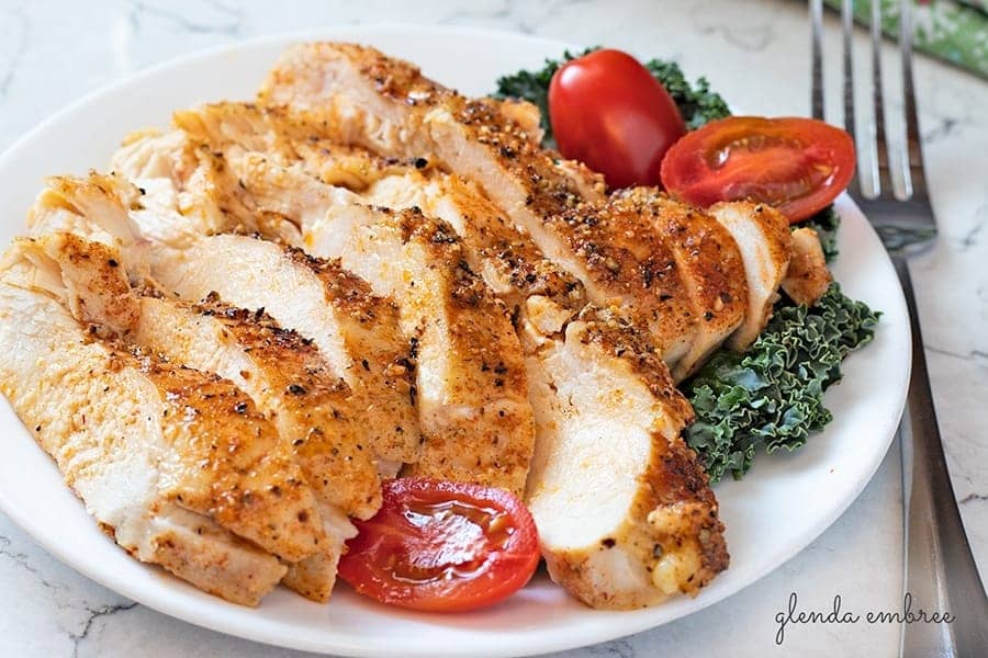 Perfect Baked Chicken breast sliced and served on a white plate.