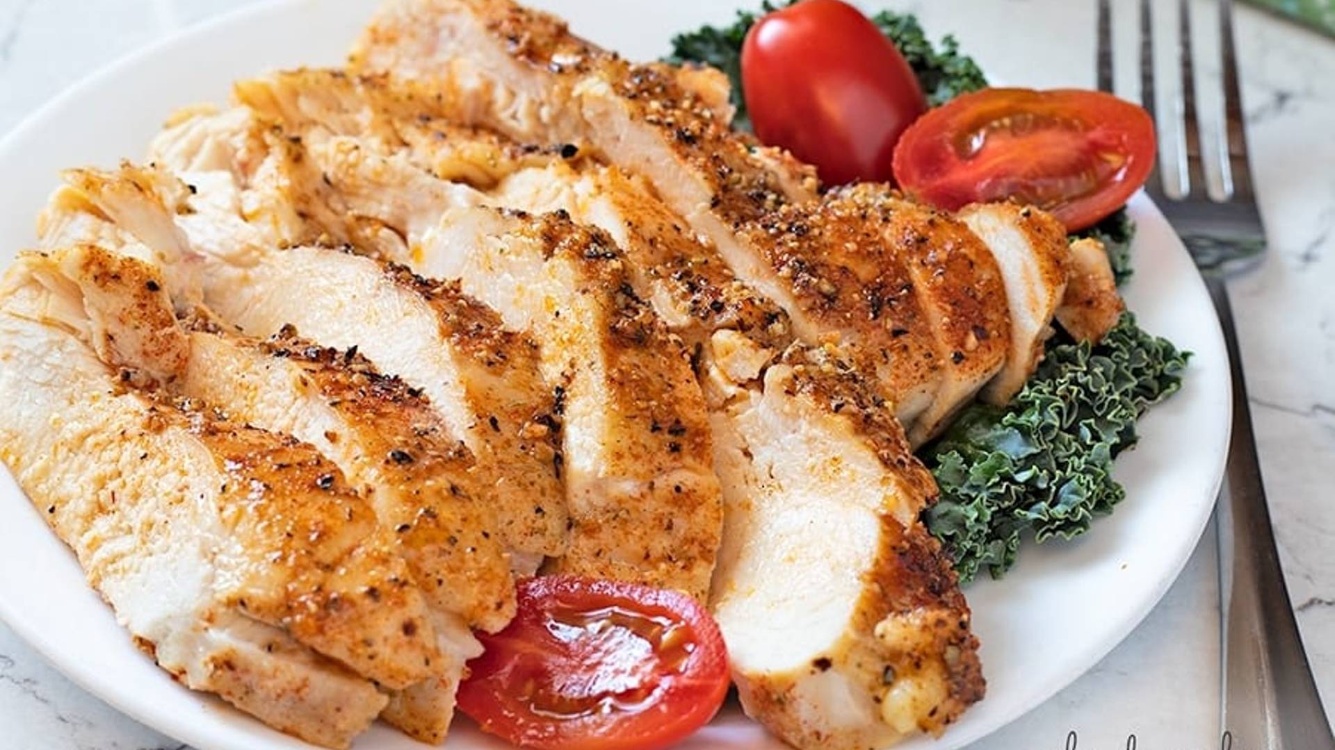 Perfect Baked Chicken Breast sliced on a white plate.