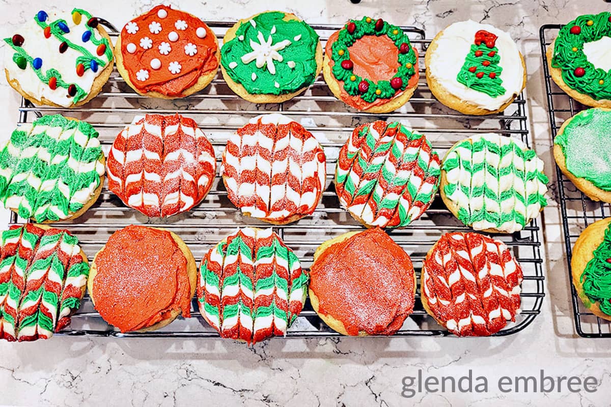 Frosted and Christmas-decorated Drop Sugar Cookies on a cooling rack.
