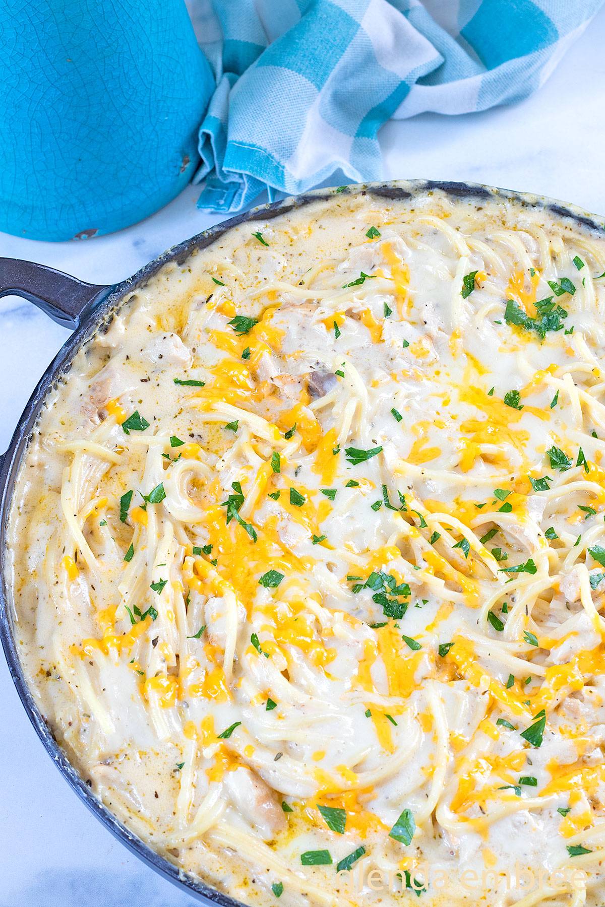 Chicken Tetrazzini in a cast iron skillet on a marble counter.
