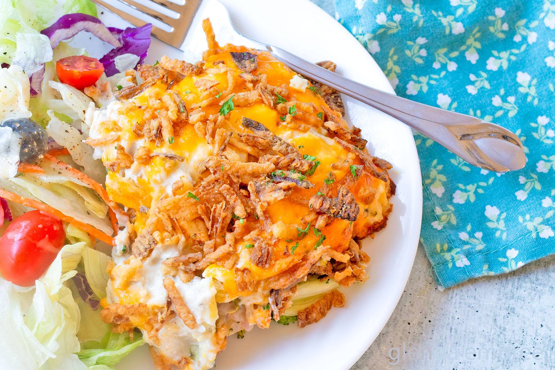 Chicken Broccoli and Cheese Casserole on a white plate with House Salad.