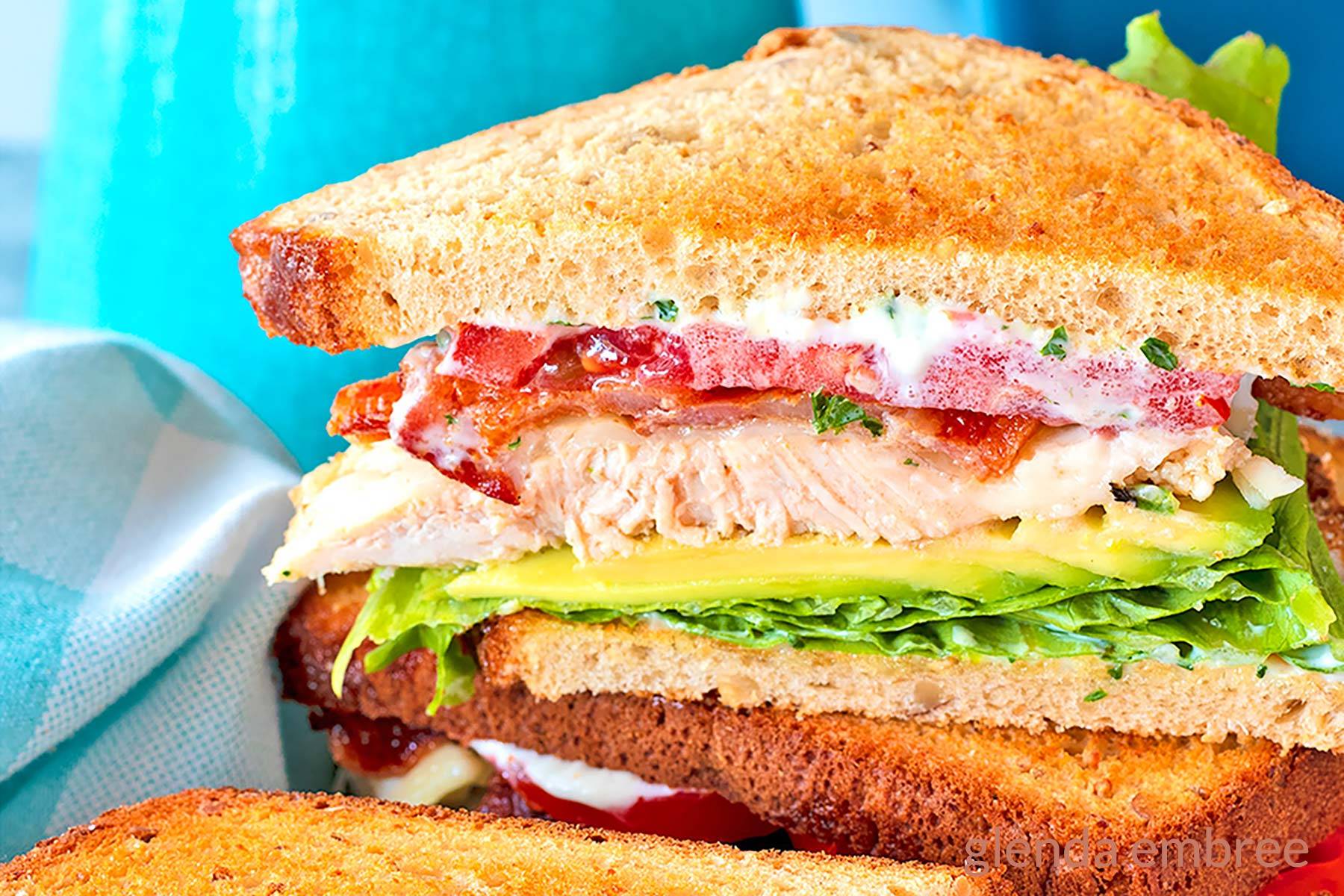 Turkey Avocado Sandwich halves stacked on a platter.