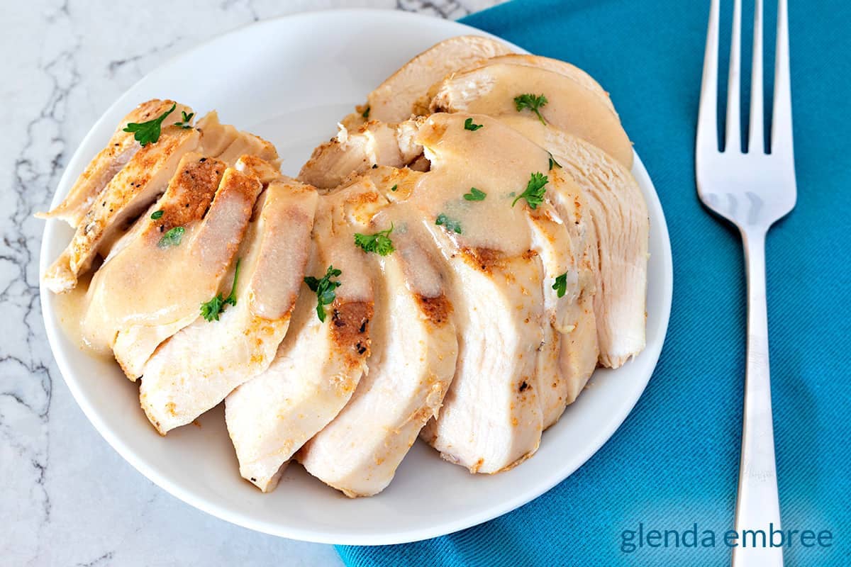 Crock Pot Chicken Breast sliced on a white plate.