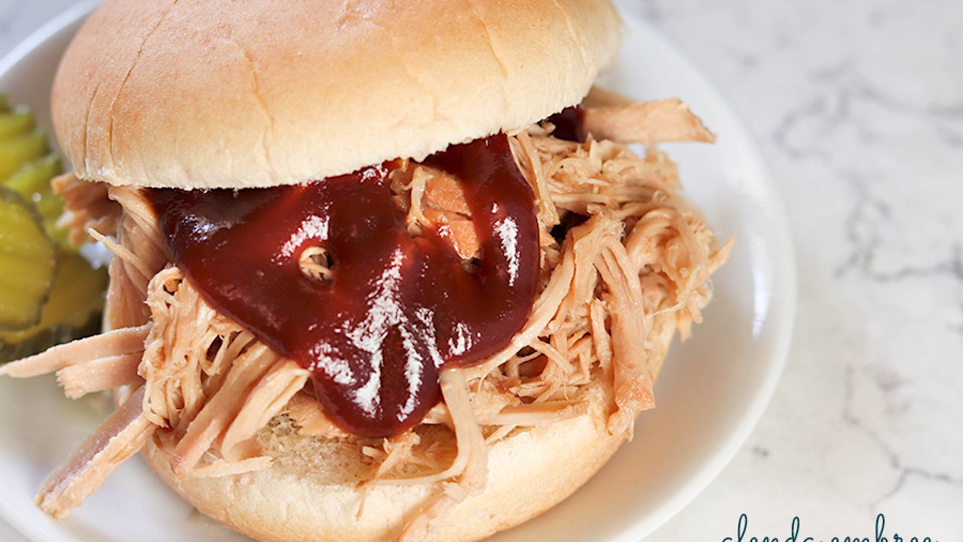 BBQ Pulled Pork Sandwich on a white plate.