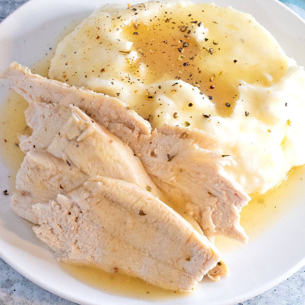 Convection Oven Turkey in a Bag on a white plate with mashed potatoes and gravy.