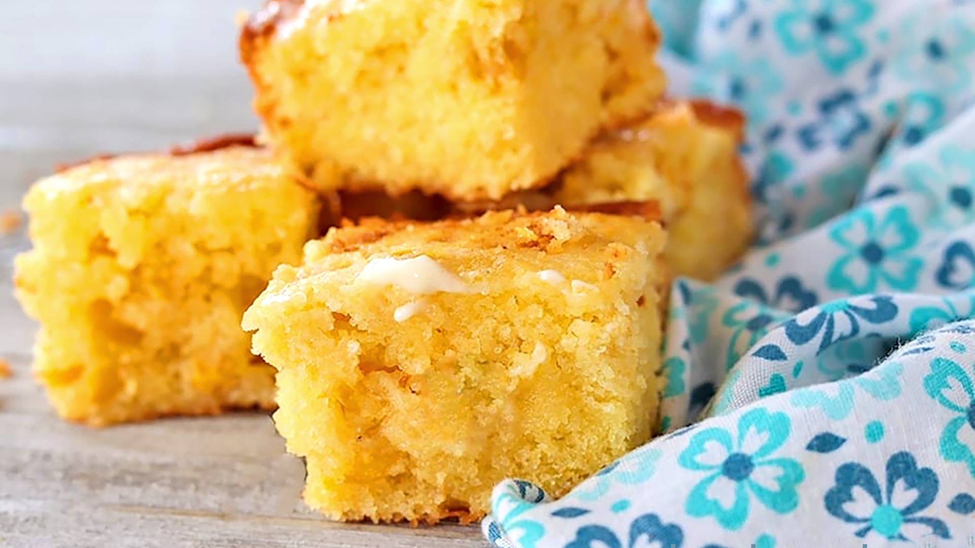 Sweet Cornbread on a concrete counter next to a blue and white print napkin.