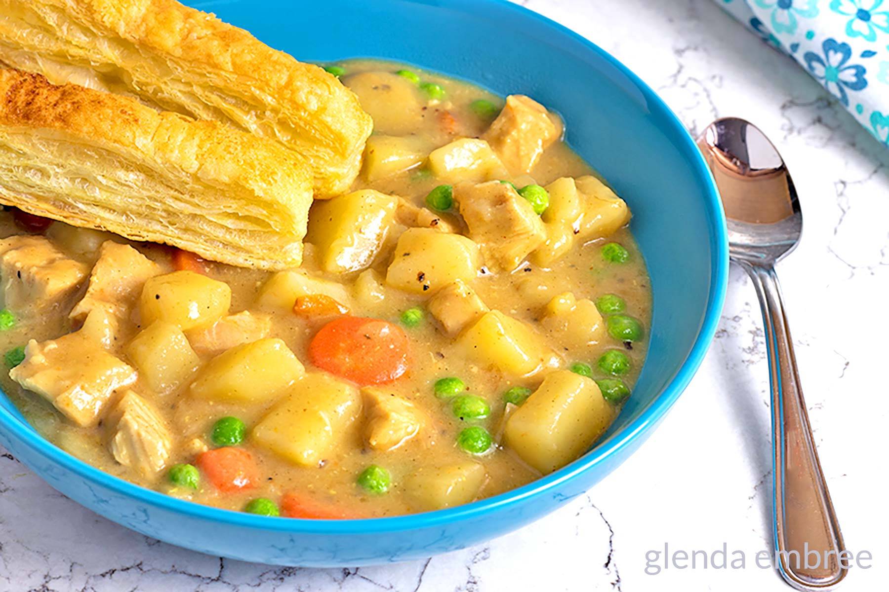 Chicken Pot Pie Soup in a blue ceramic bowl.
