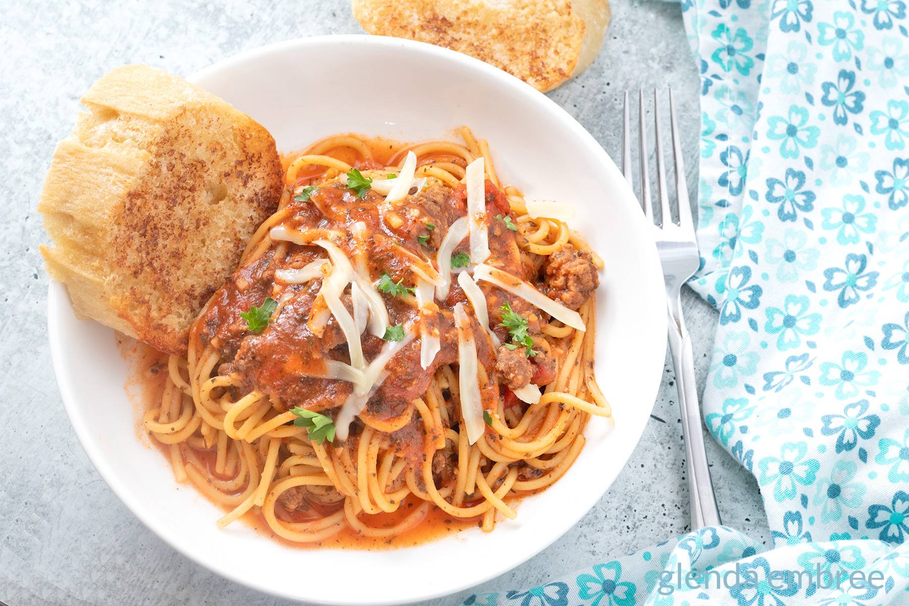 Easy One Pot Spaghetti in a white bowl with garlic toast.