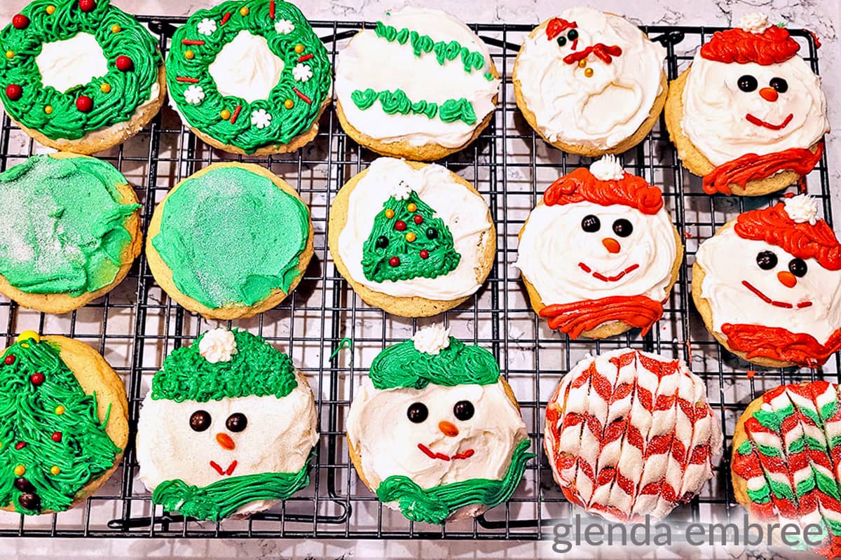 Frosted and Christmas-decorated Drop Sugar Cookies on a cooling rack.