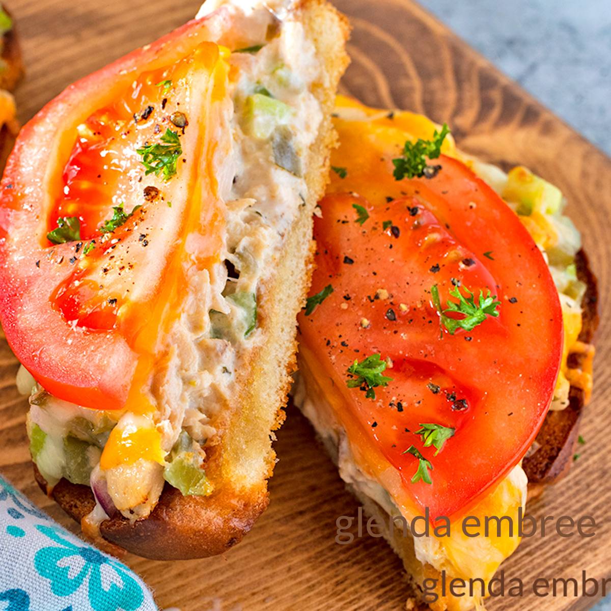 Tuna Melt Open Face sandwich on a wooden cutting board.