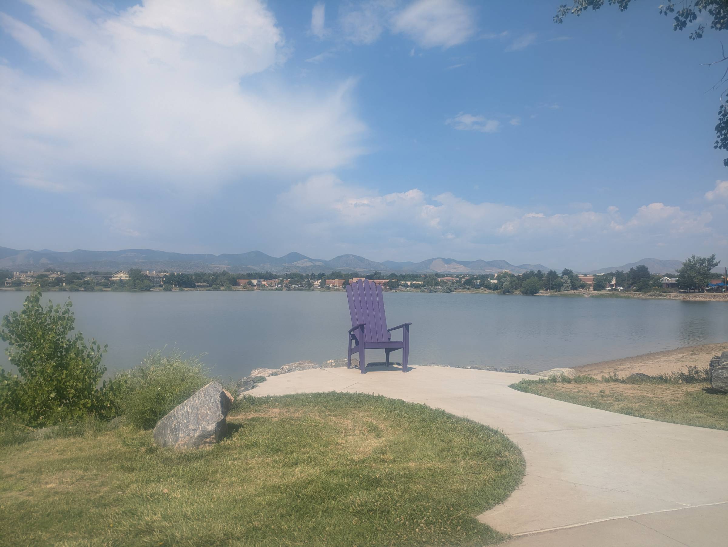Large purple chair at a park in front of a reservoir