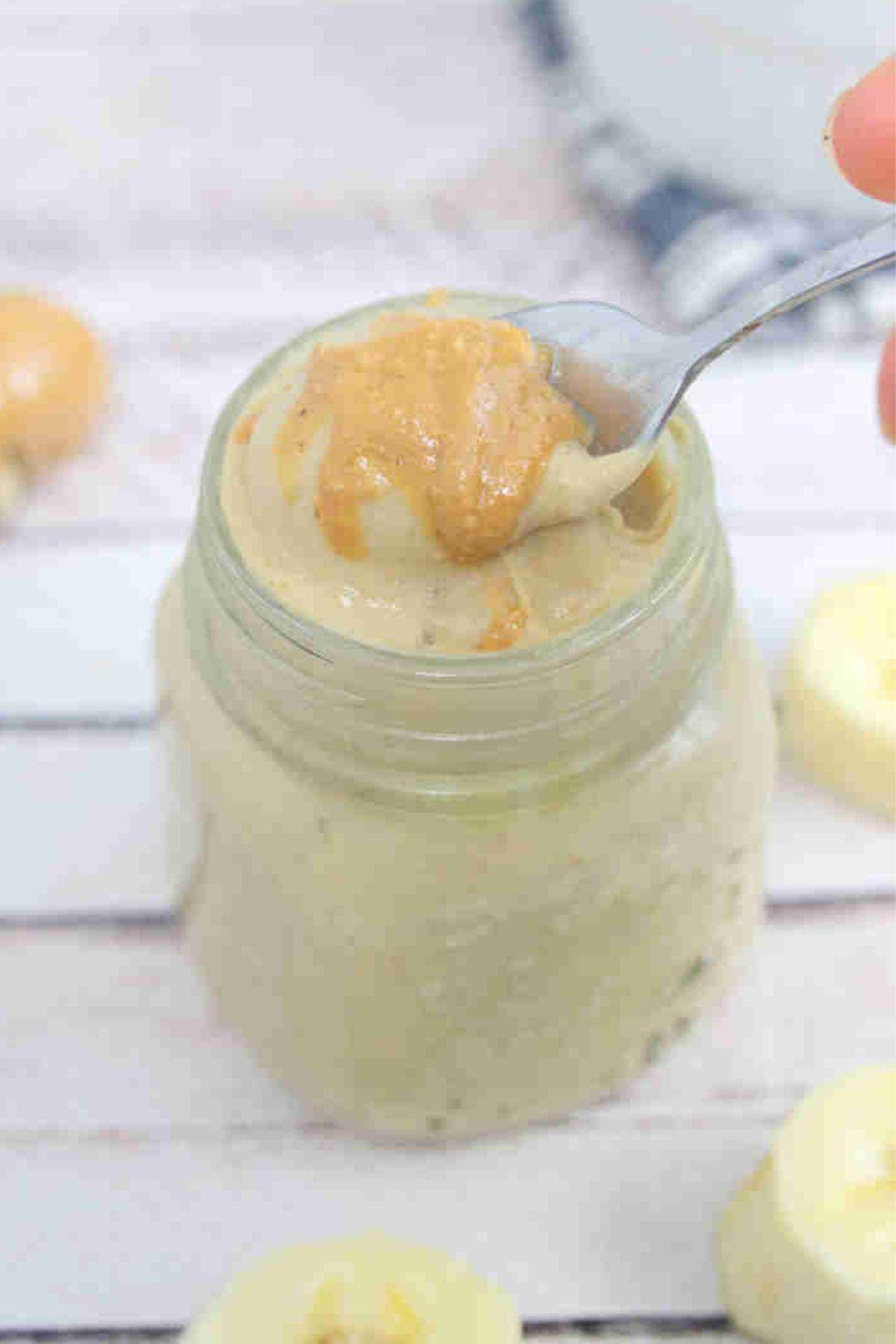 Banana pudding in a jar with peanut butter on top.