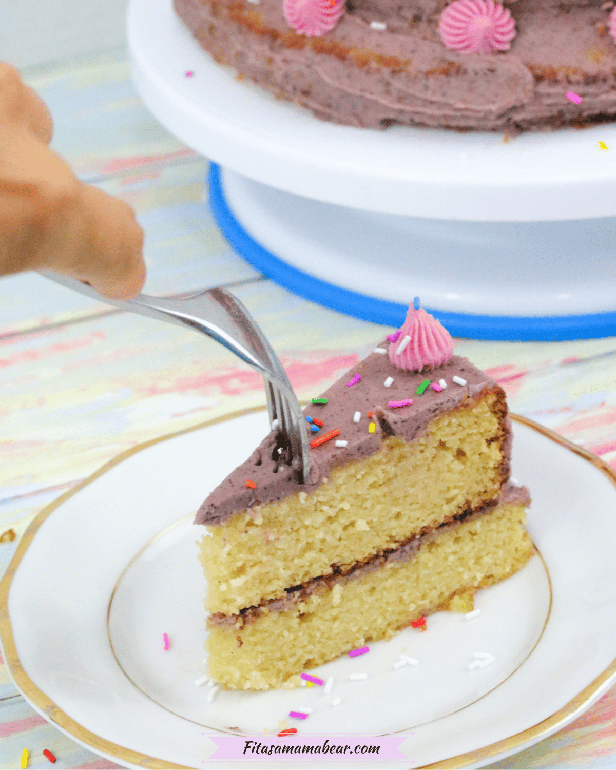 Birthday cake on a plate with a fork being put into it.