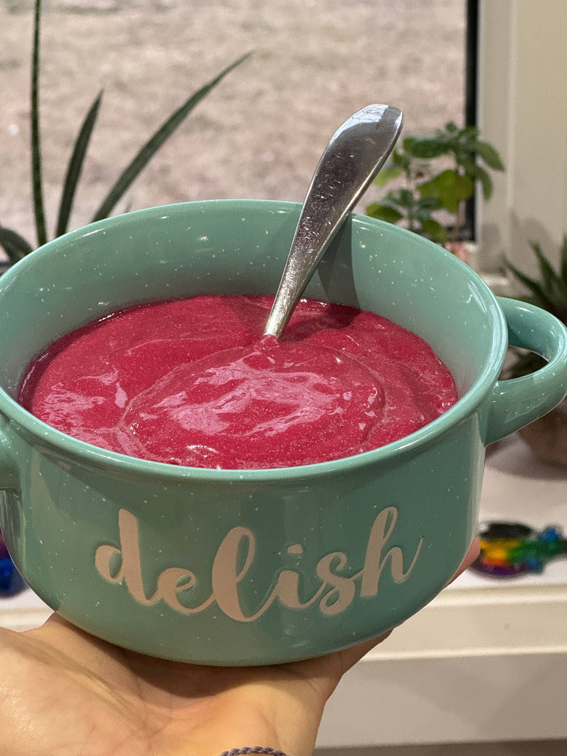Bright pink beet smoothie in a green smoothie bowl.