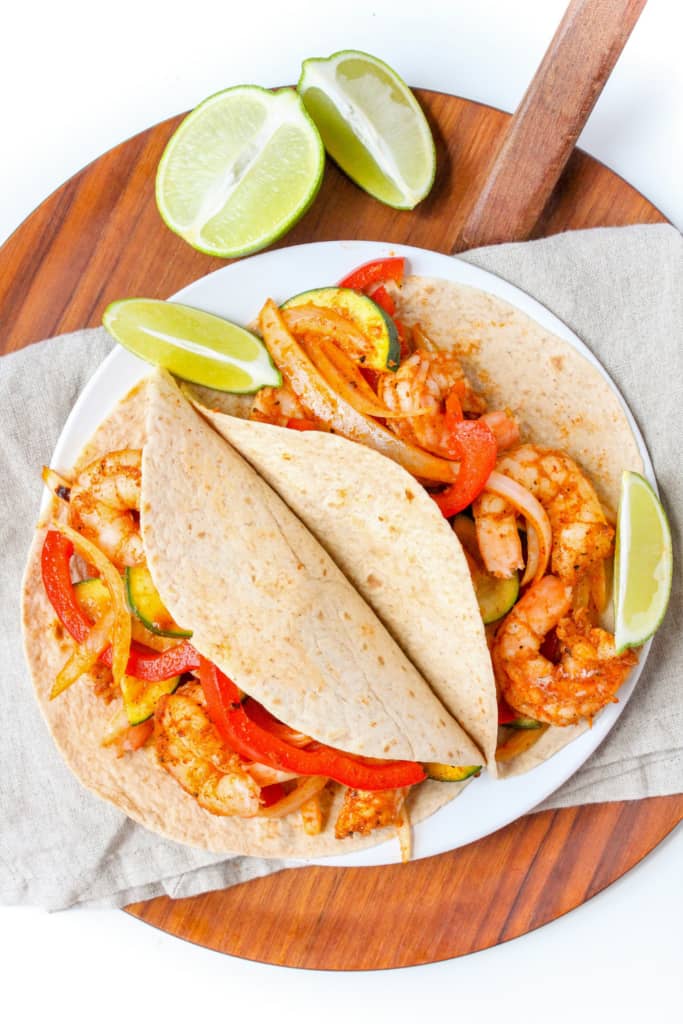 Shrimp fajitas in a wrap on a cutting board.
