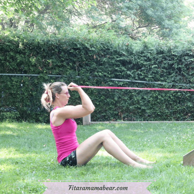 Woman outside performing a bicep curl.