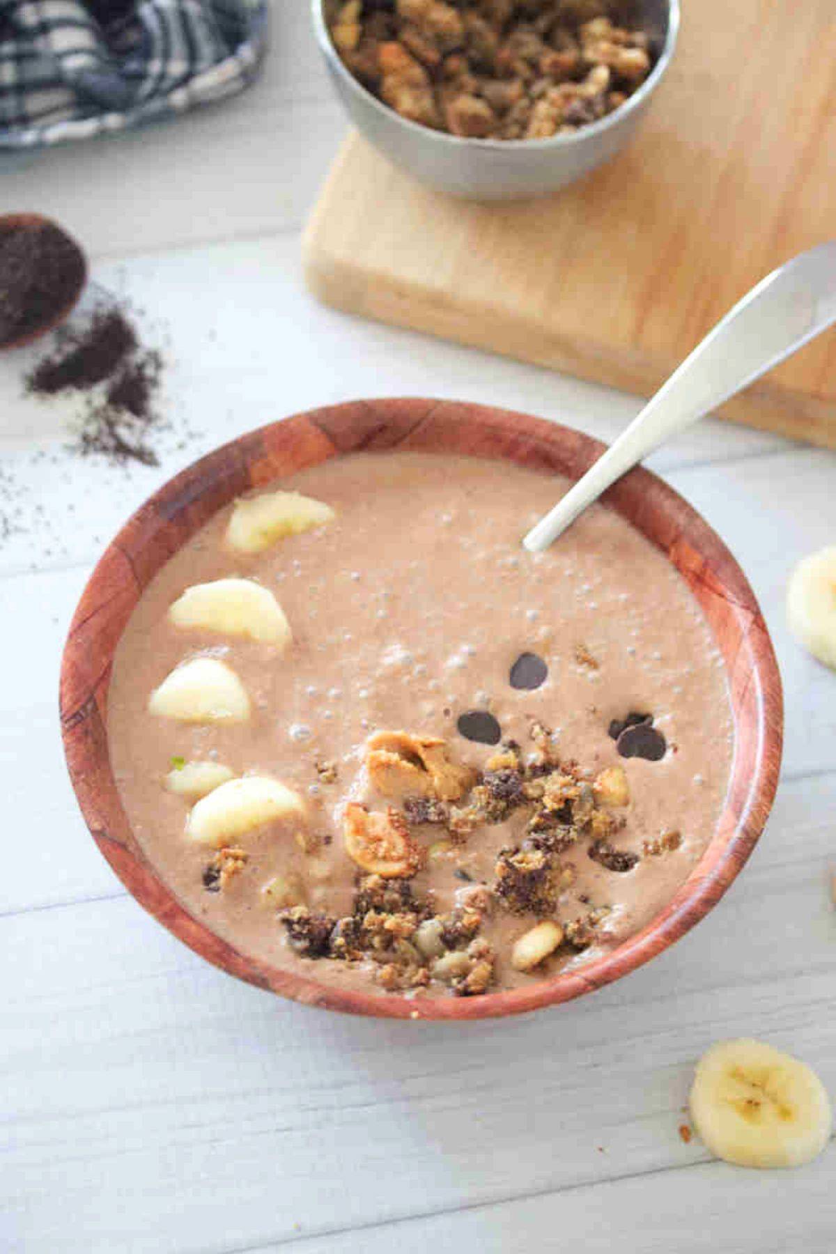 Coffee smoothie bowl in a wooden bowl with granola.