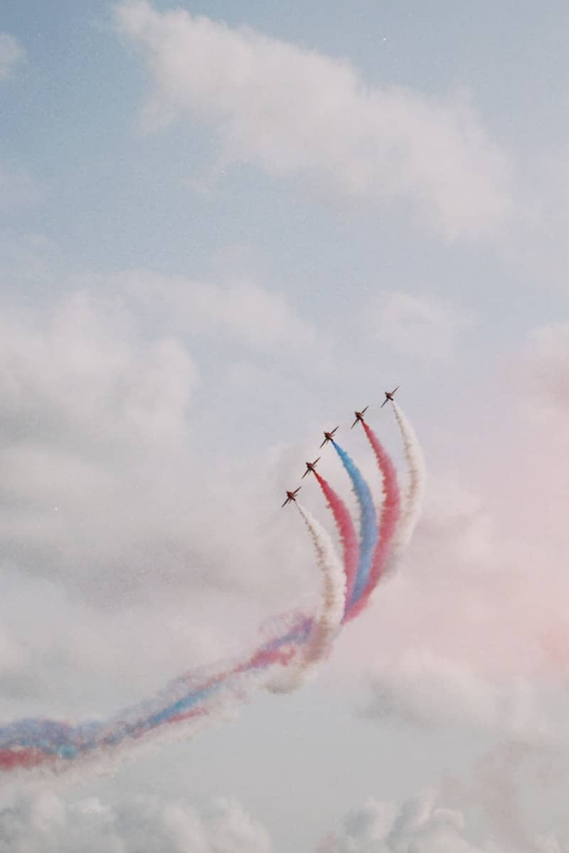 Aerobatic jets trail smoke in the sky.
