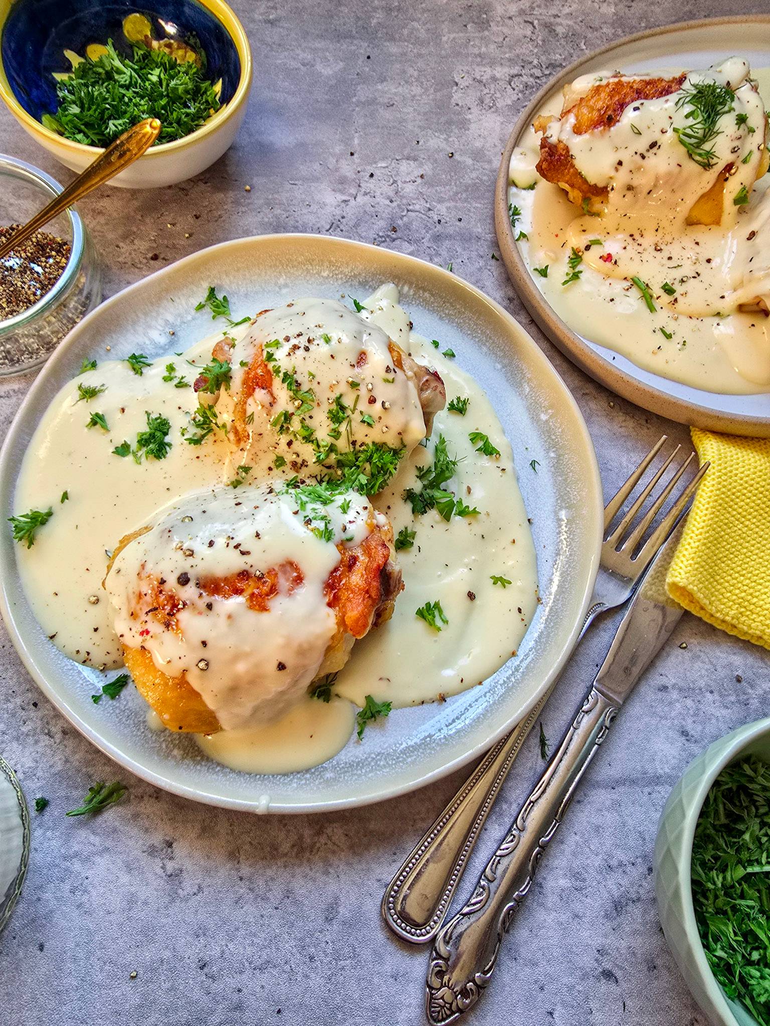 Ciulama served on a white plate with a creamy sauce and a sprinkle of fresh parsley.