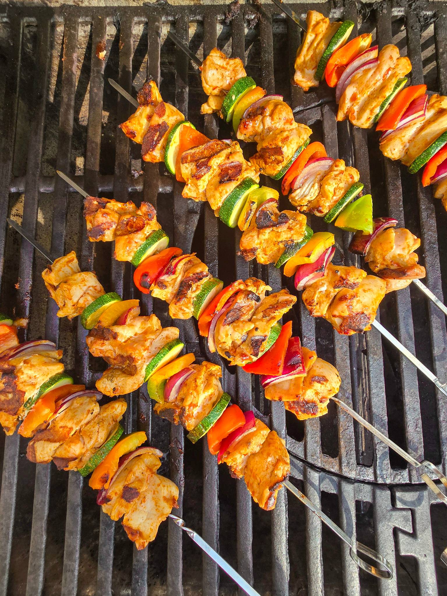 Grilled harissa chicken skewers with Mediterranean veg.