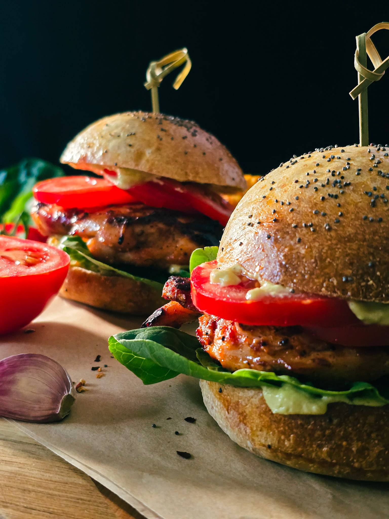 Two buttermilk chicken burgers with avocado dressing, tomato and lettuce. 
