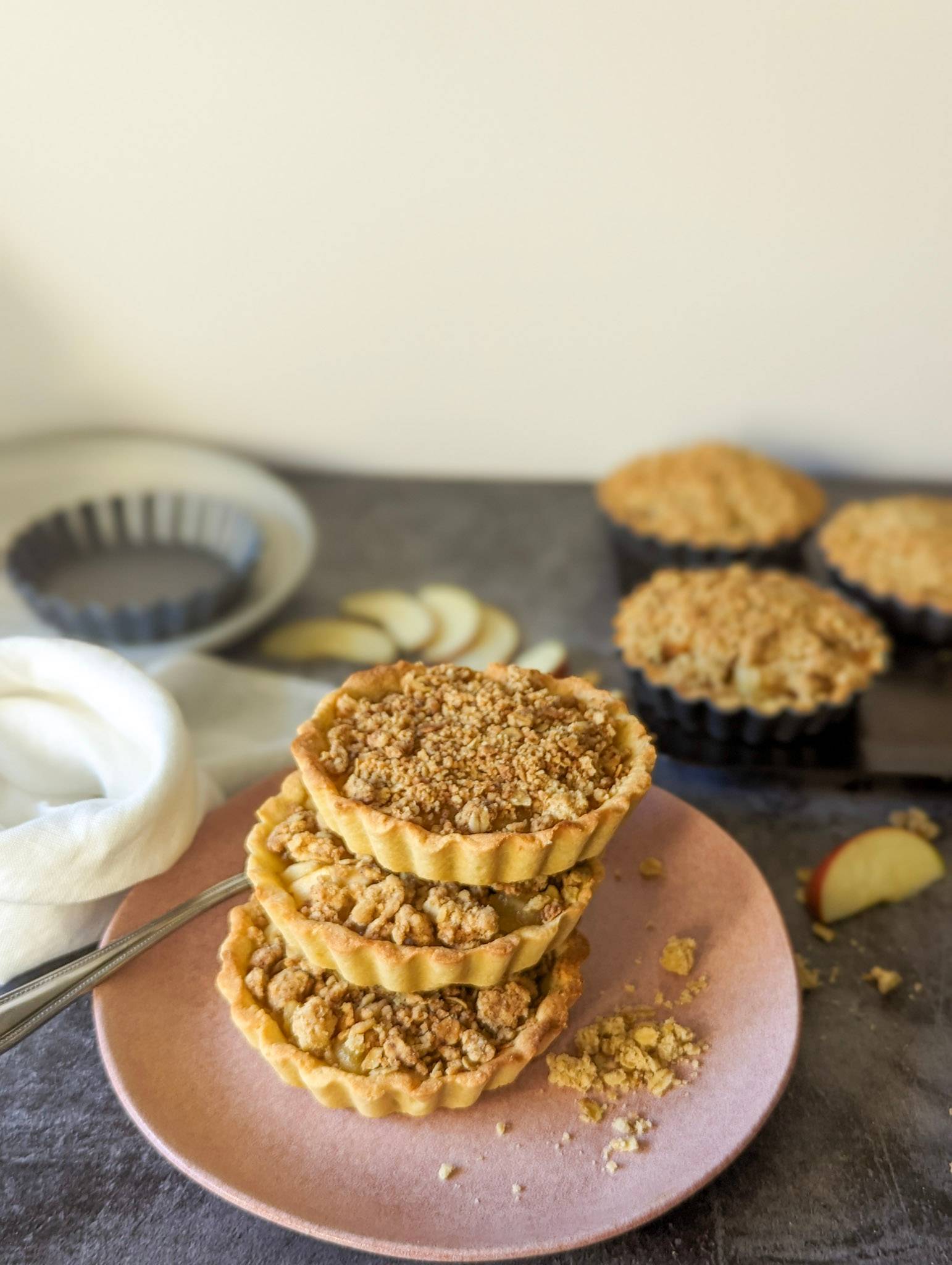 Apple tartlets with streusel toppings on a pink plate