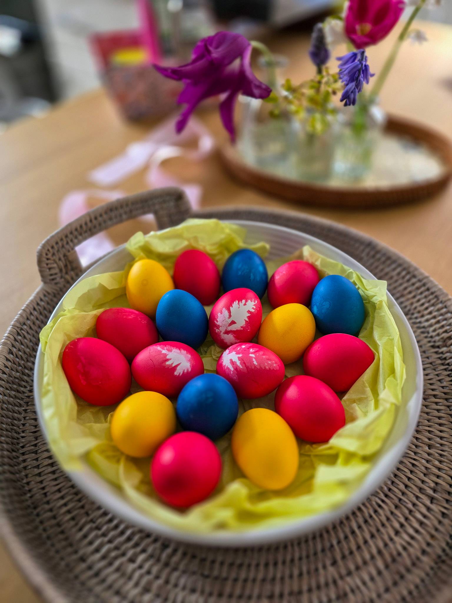 A basket filled with red yellow and blue dyed Easter eggs