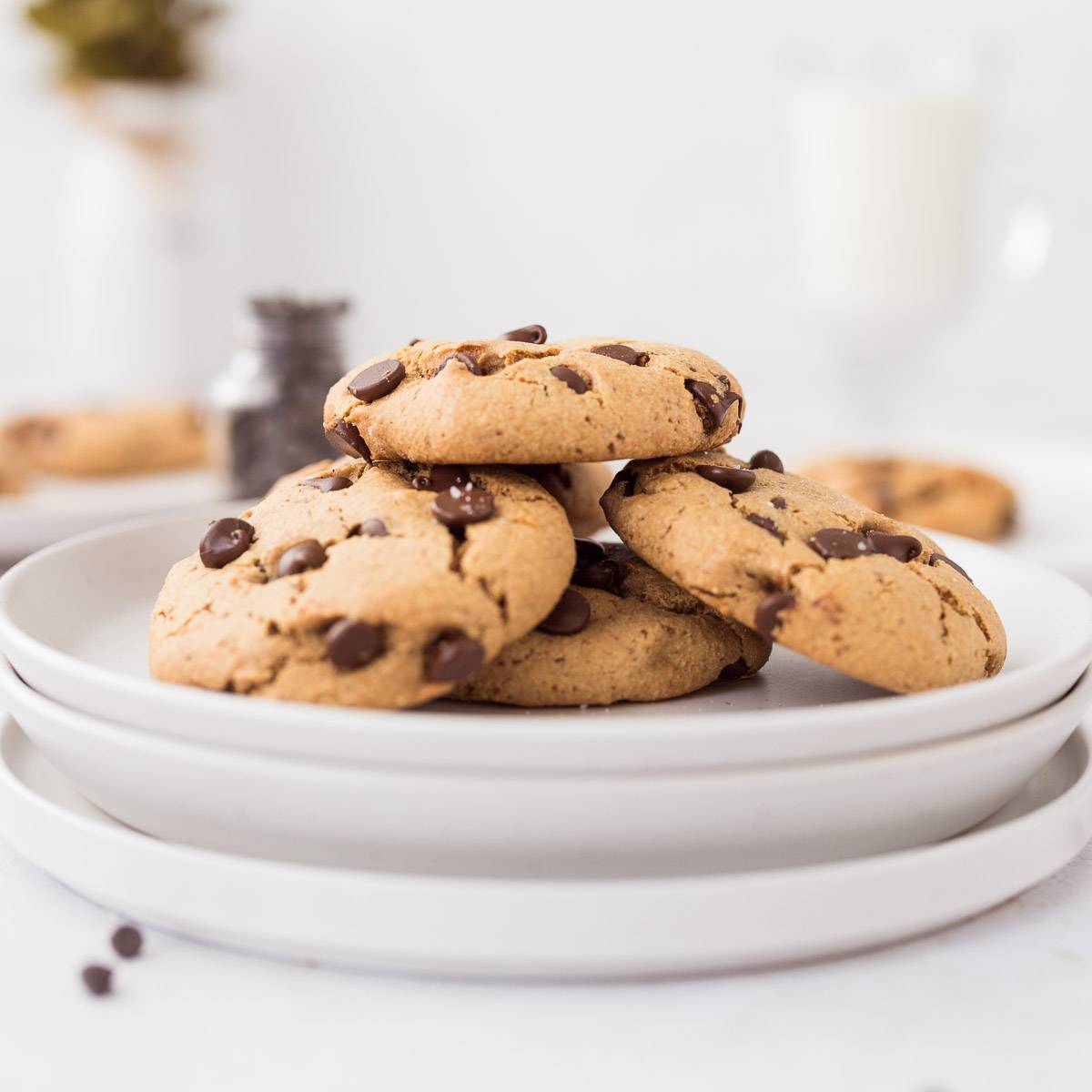 chocolate chip protein cookies stacked on white plate