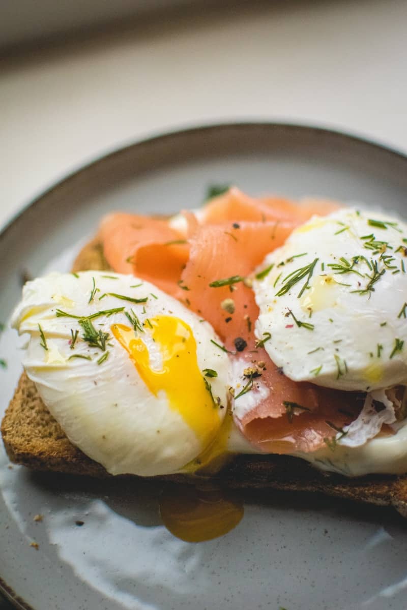 Smoked salmon and poached eggs on toast with dill.