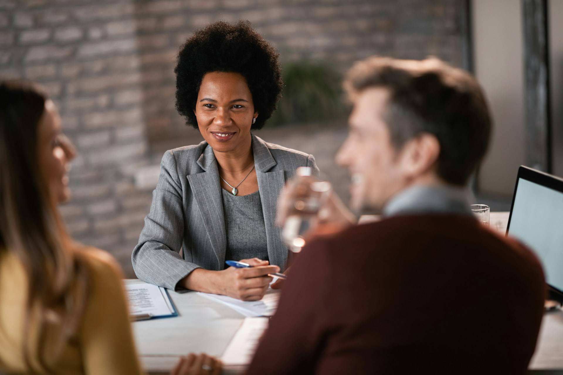 Black financial advisor meets with couple about retirement.