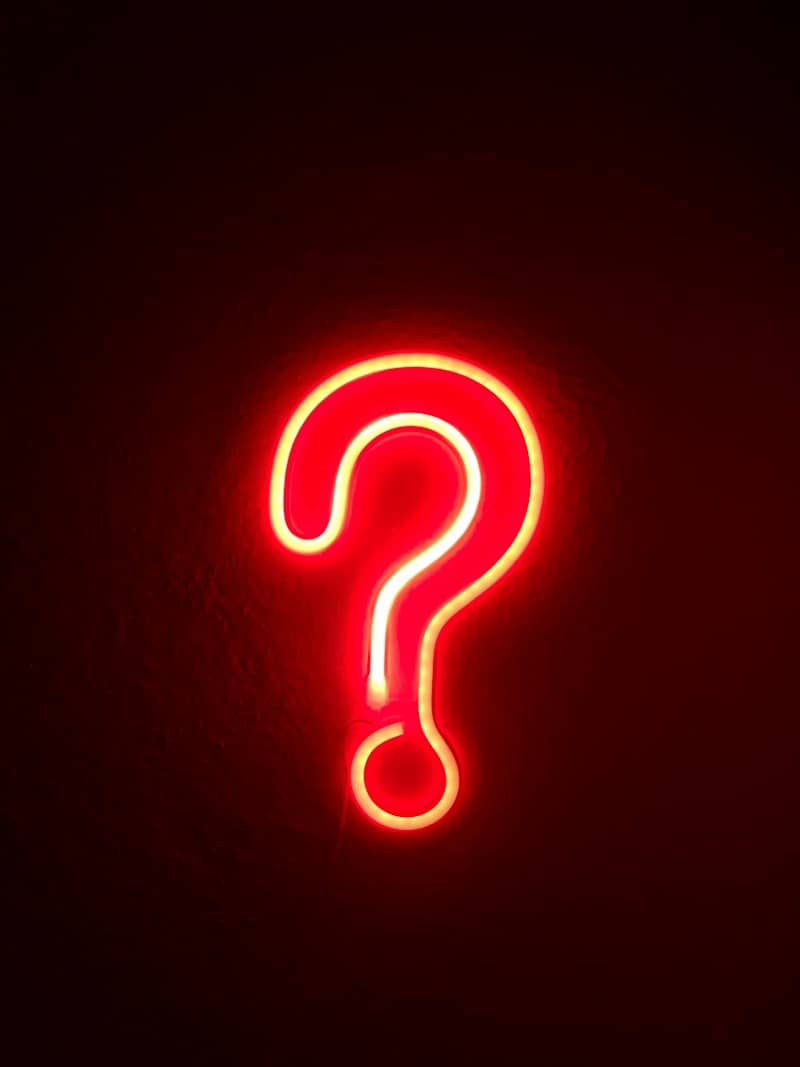 red neon question mark on wall