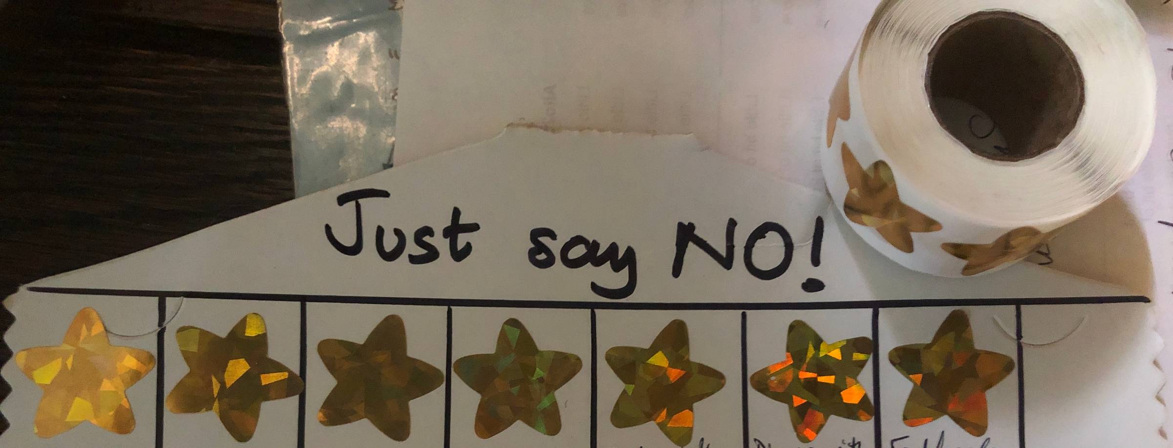 A roll of stickers and a piece of card with a handwritten header "Just say NO!" and a row of gold stars.