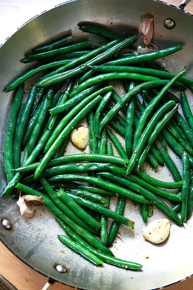 A skillet filled with cooked green beans. 