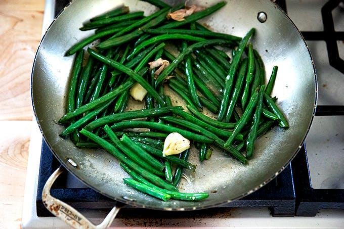 Cooked green beans in a skillet stovetop. 