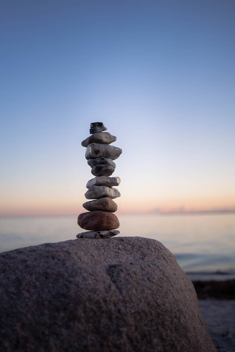 Stack of stones balanced on a rock at sunset.