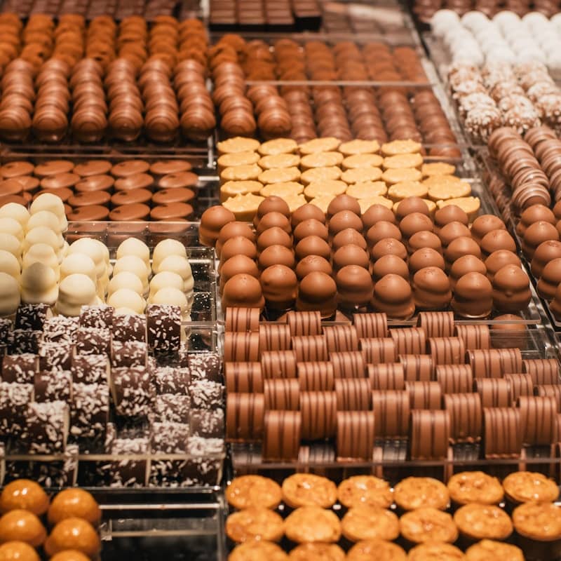 Rows of delicious, assorted chocolates are displayed.