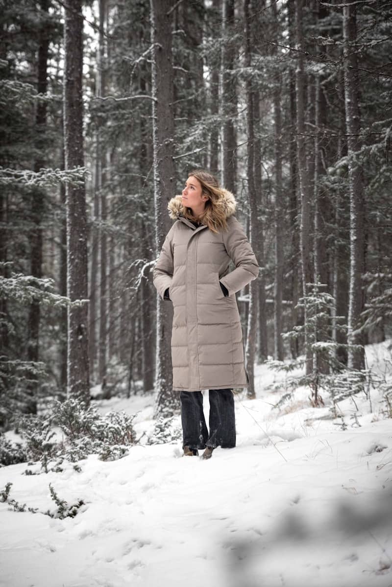 A woman standing in the snow in the woods