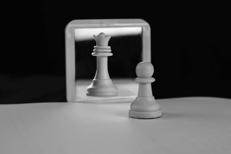 A chess pawn reflects as a queen in mirror.