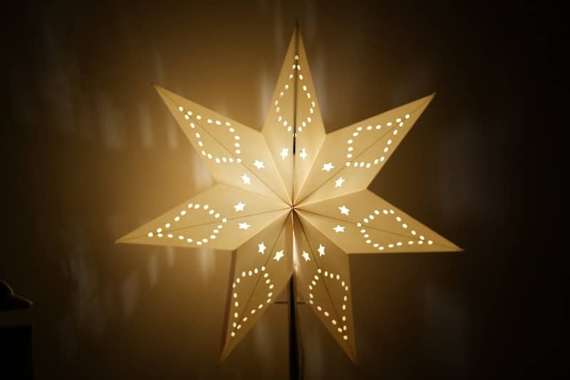 A lit paper star lantern glows warmly.