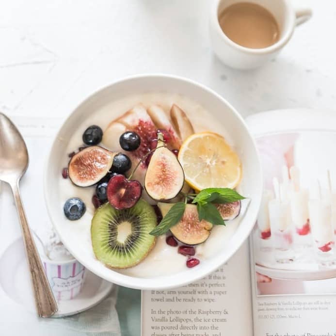 white ceramic plate beside gray steel spoon
