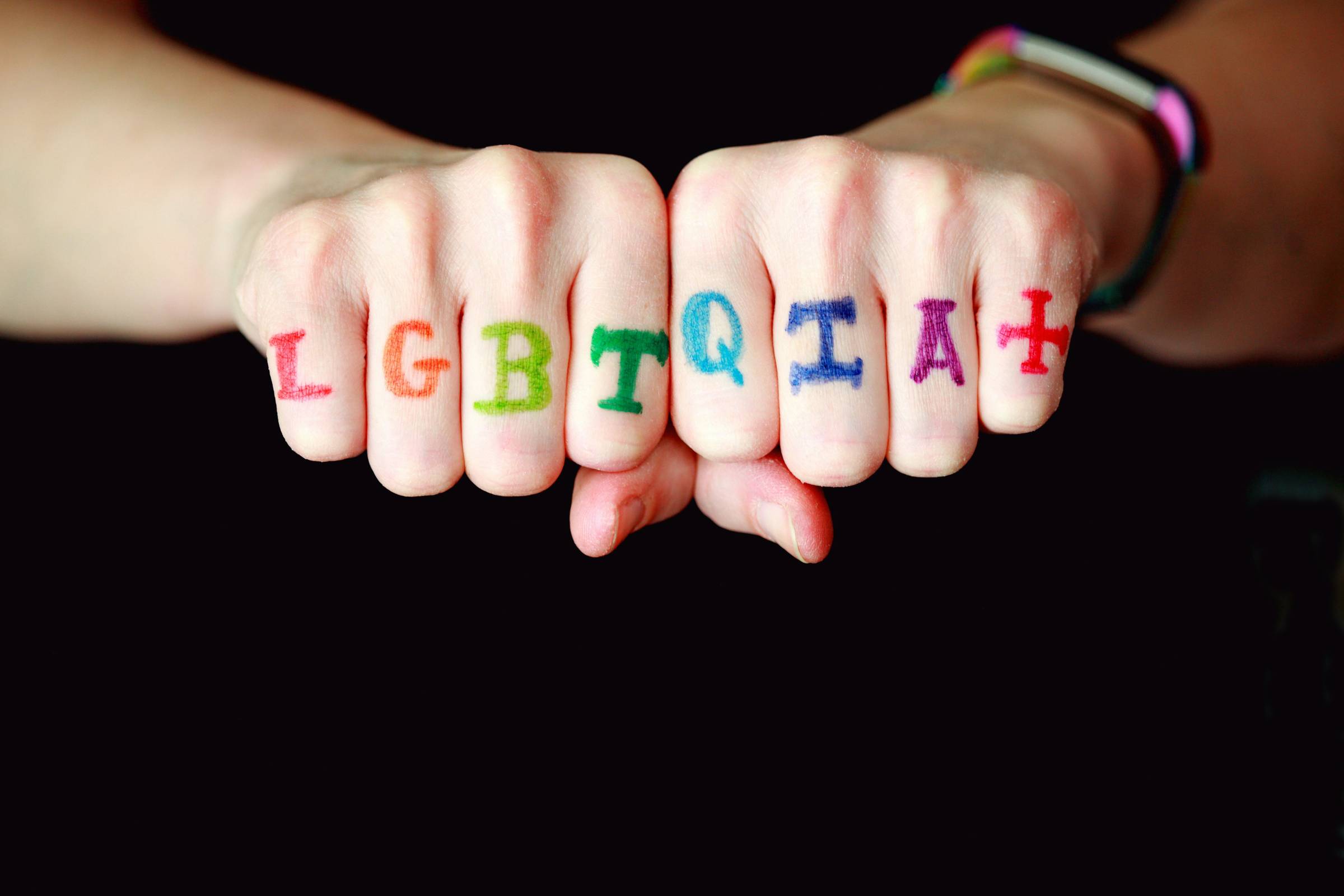hands with LGBTQUIA+ painted on fingers