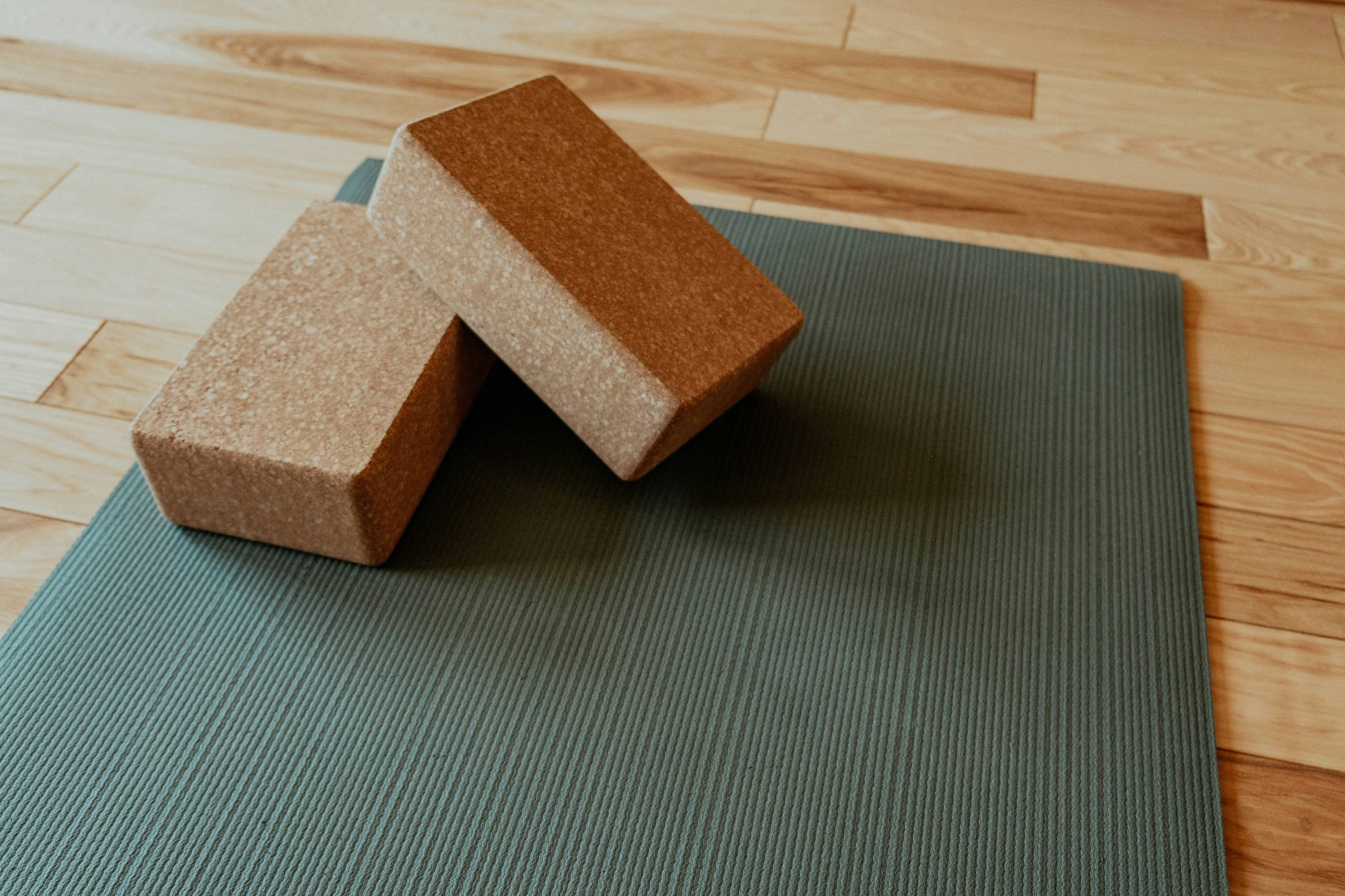 two cork yoga blocks on a yoga mat