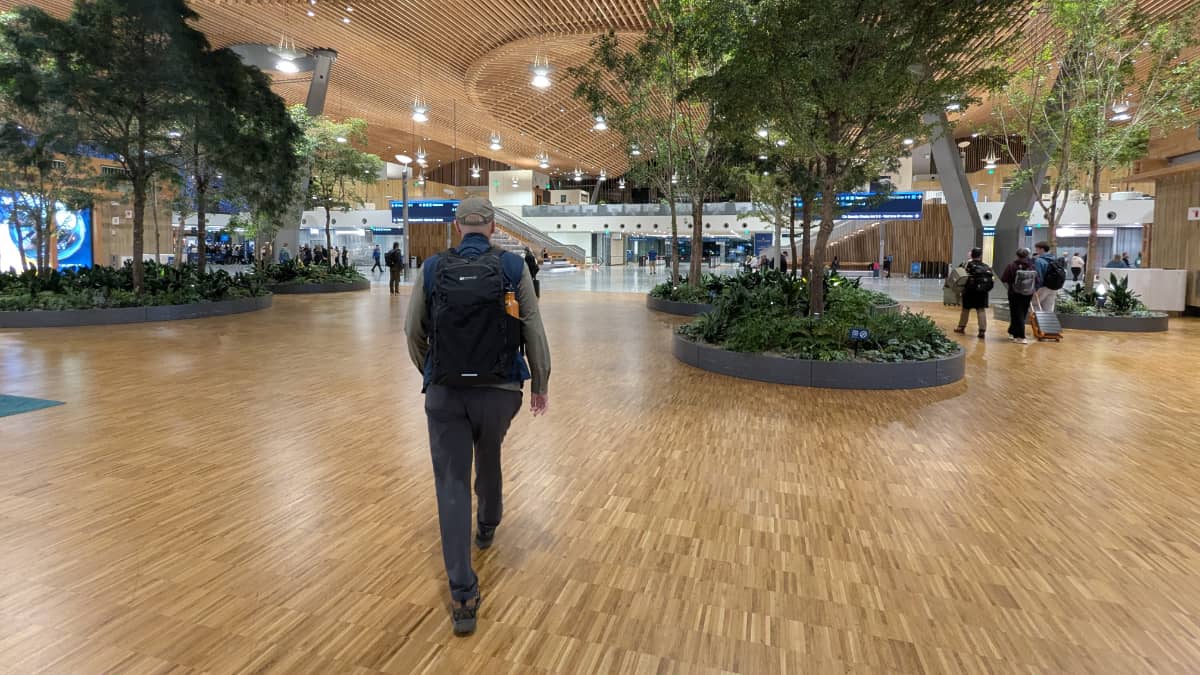 Man walking through the Portland Airport with a small backpack