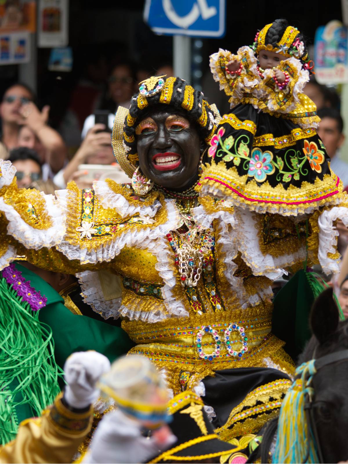 Mama Negra in gold robes and dress rides through the streets of Latacunga