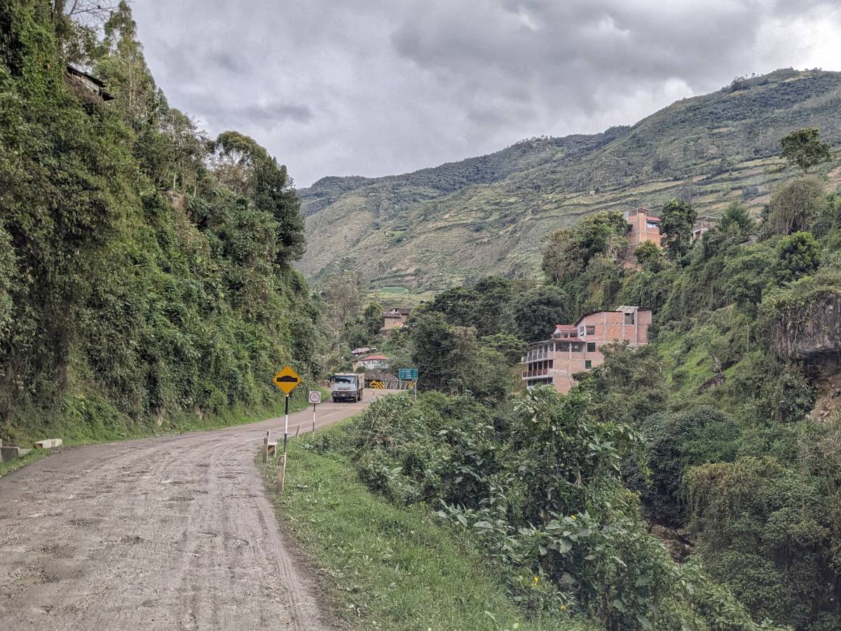 image: dirt road leading into a town perched on a mountainside in the Peru's Amazonian Andes