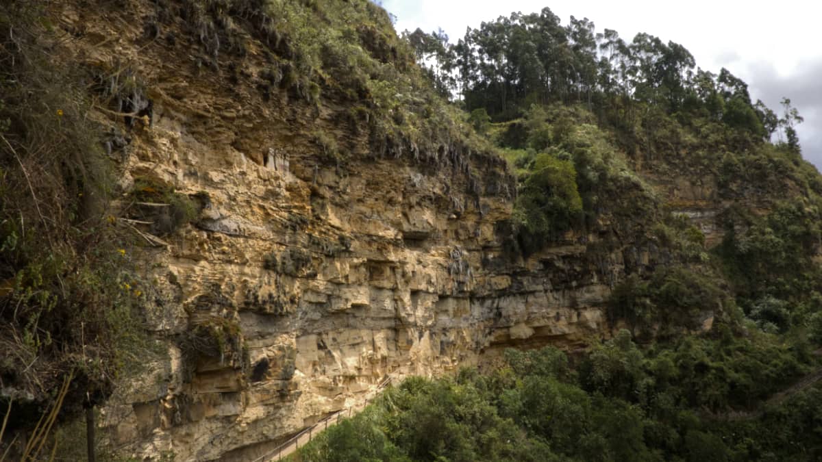 Five earth toned sarcophagi perch in a niche on a cliffside in Chachapoyas, Peru