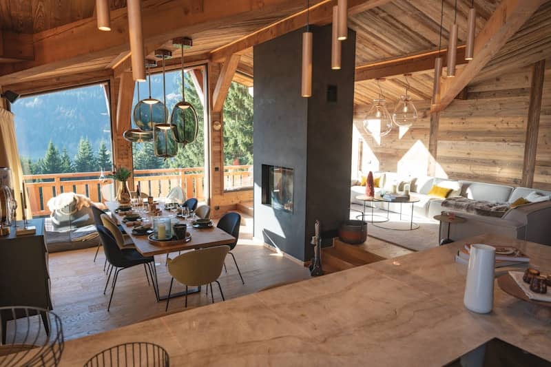 Luxurious wooden chalet interior with dining and living areas.