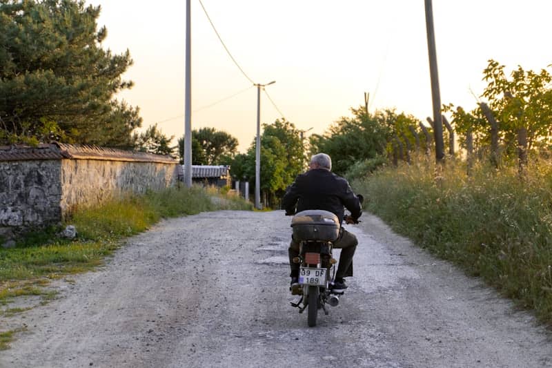 A man riding a motorcycle down a dirt road