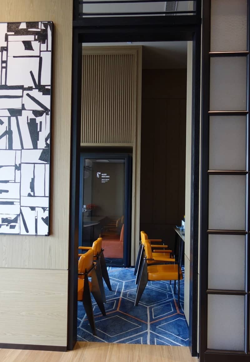 Orange chairs in a modern room with abstract art.